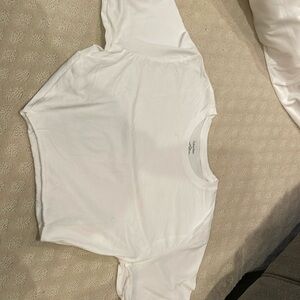 A white, short-sleeved t-shirt with a slightly frayed hem.